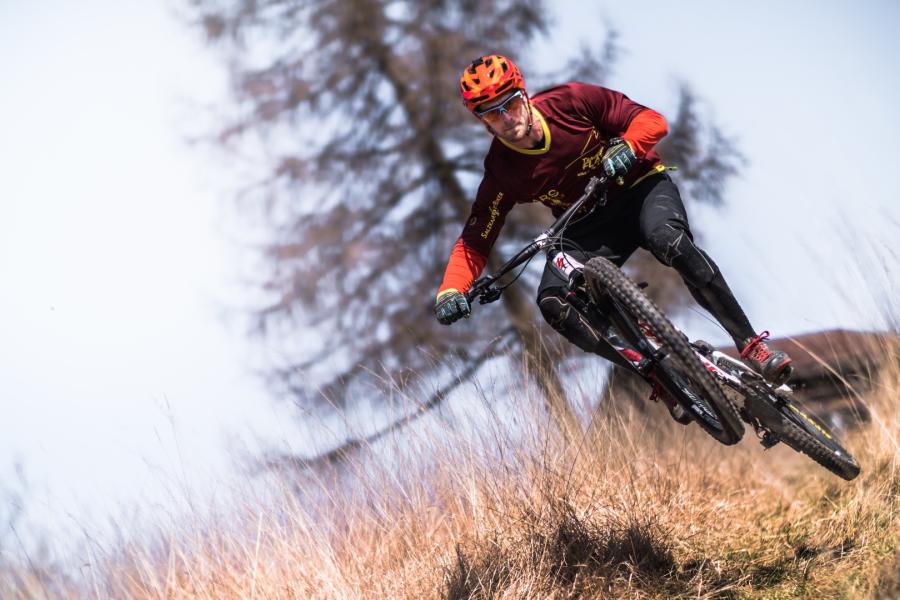 Biker in discesa su sentiero Gara giovanile di mountain bike